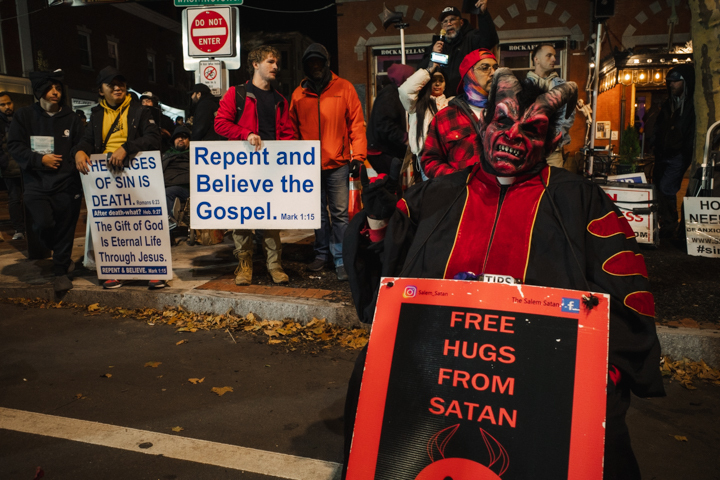 Satan offering free hugs in front of some proselytizers