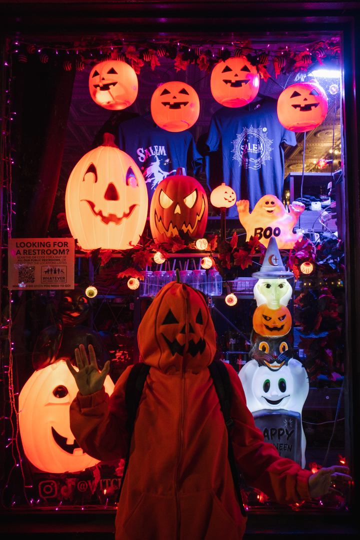Me dressed as a pumpkin standing in front of a jack o’ lantern display